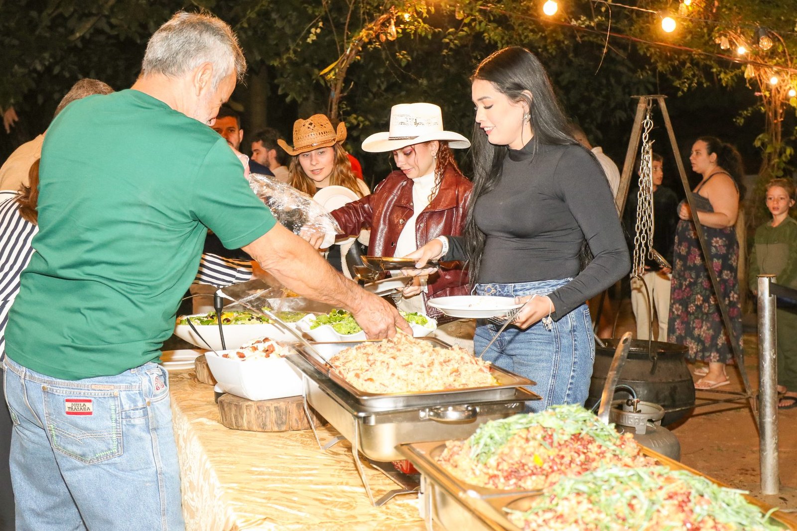 Convidados sendo servidos no buffet durante o evento